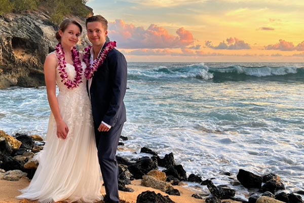 Couple walking on the beach after their wedding in Kauai, HI title=
